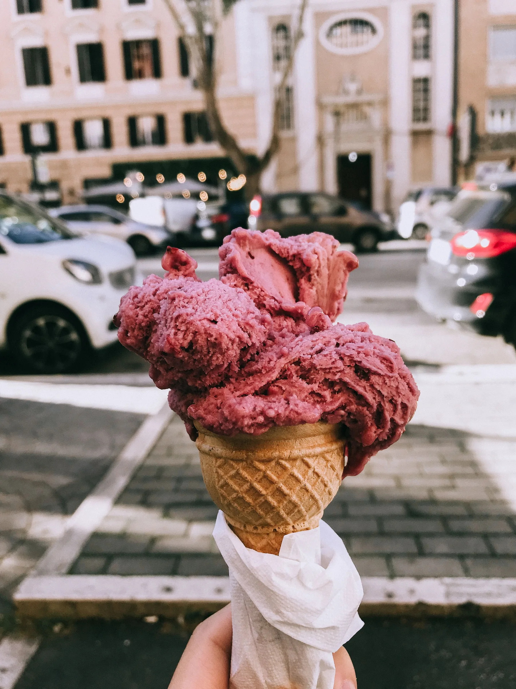 Berry gelato cone held outdoors